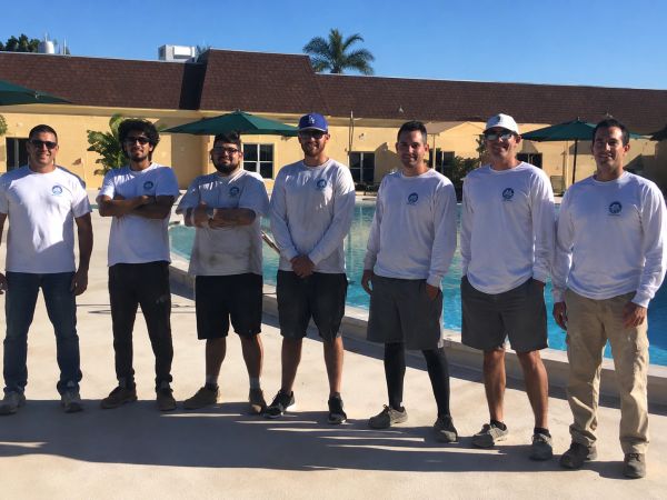 Concrete installation team beside swimming pool
