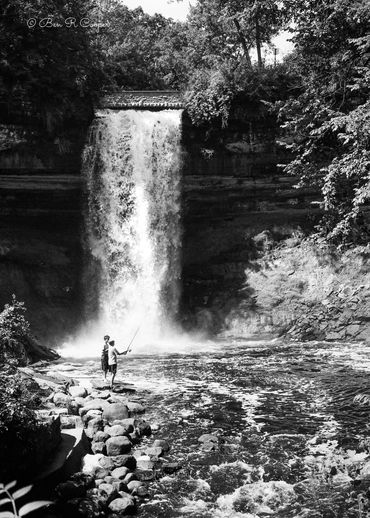 2 kids fishing at Minnehaha Falls in Minneapolis Minnesota. Water Falls, black and white film photo