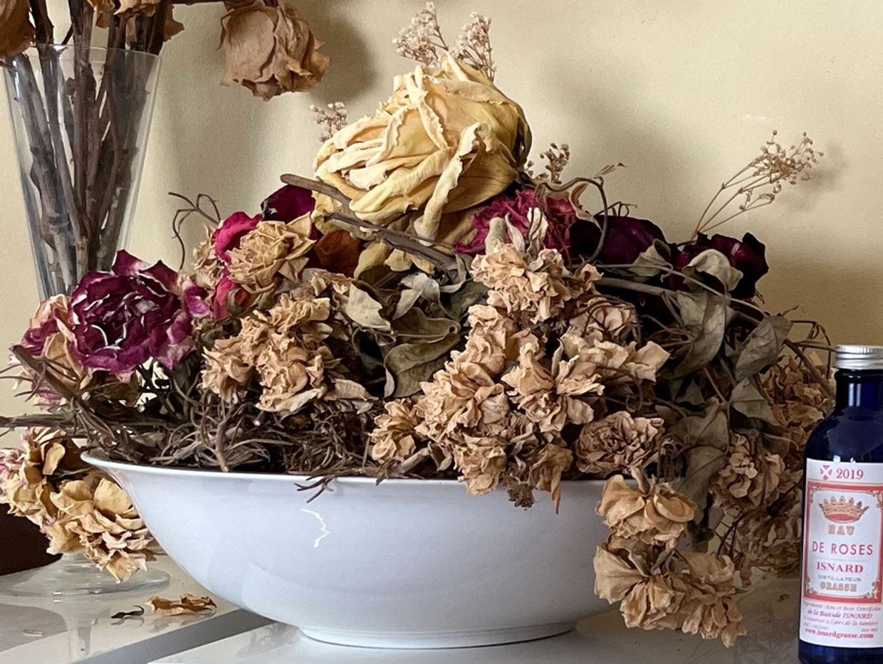 Shelf with bowls with dry flowers, bottles of rose water and lavender essential oil from Grasse, pes