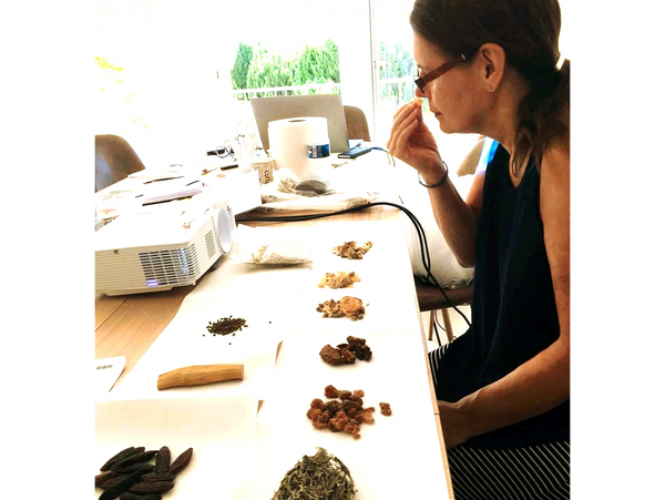 Ana Sastrias smelling raw materials in their original state as plants, seeds, acorns, resins, bark