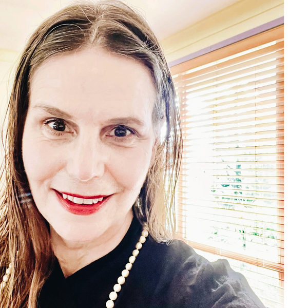 Portrait of Ana Elena Sastrias wearing black top with pearls collar, shiny day at the background.