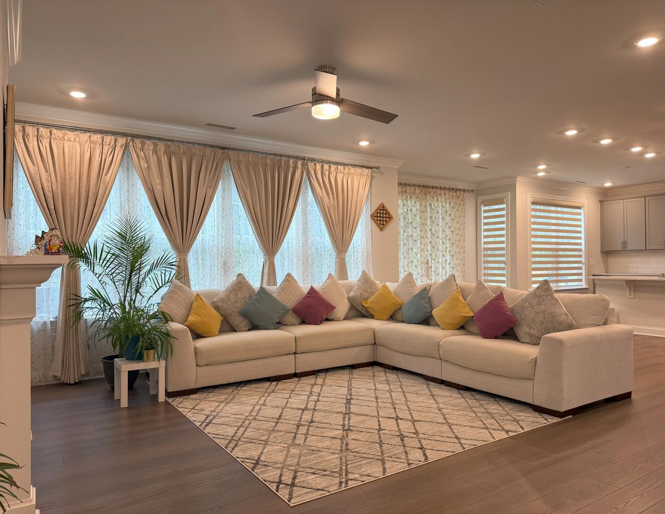 Spacious living room with beige sectional sofa and colorful cushions.