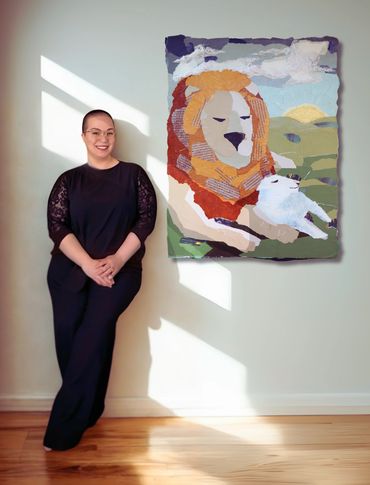 A woman standing next to a painting of a lion.