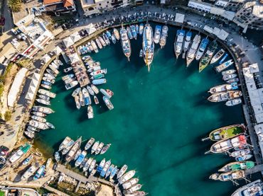 Aerial view of a harbor filled with boats and surrounded by buildings.