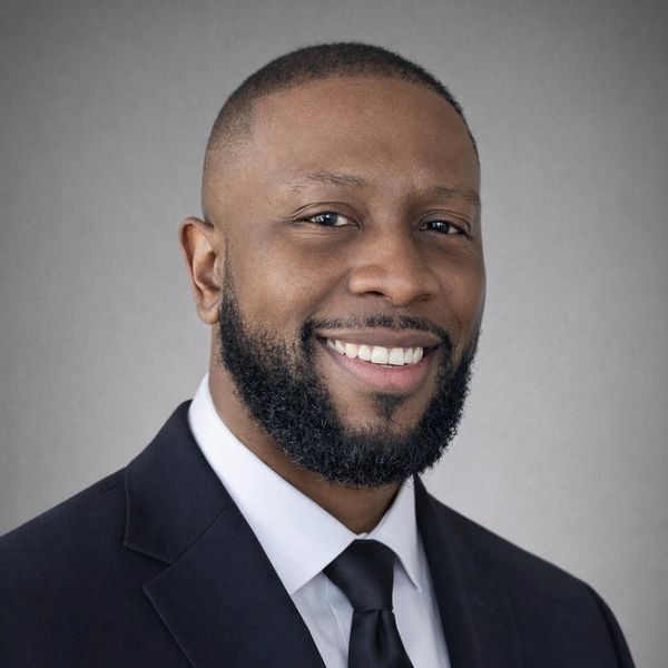 Man in a suit smiling.