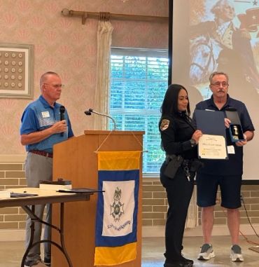 Police officer receives an award during a ceremony.