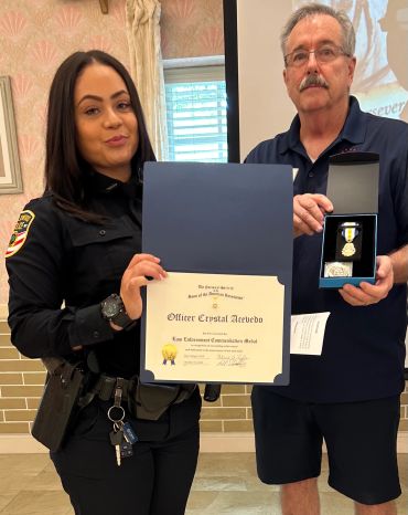 Officer Crystal Acevedo receives an award and medal.