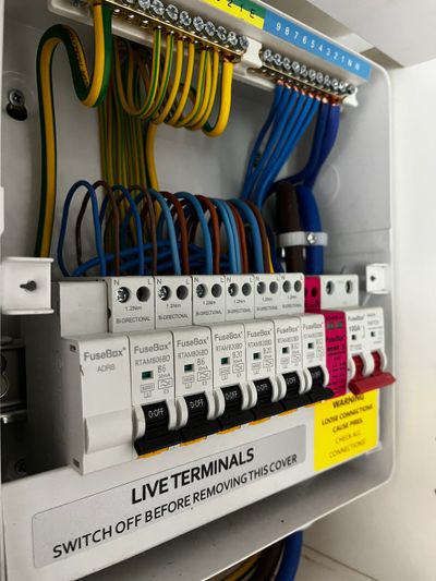 Close-up of an electrical fuse box with labeled switches and organized wires, from a recent home rewire.