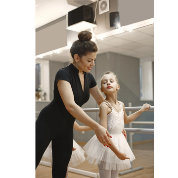 Dance teacher helping ballet dancer class.