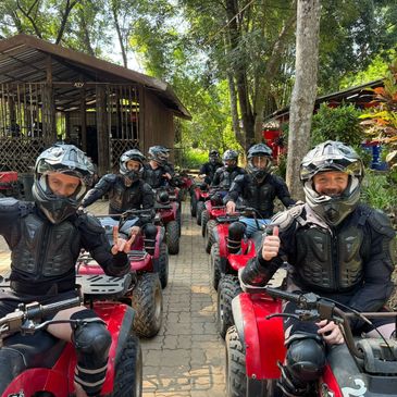 Group of people on red ATVs wearing helmets and protective gear.