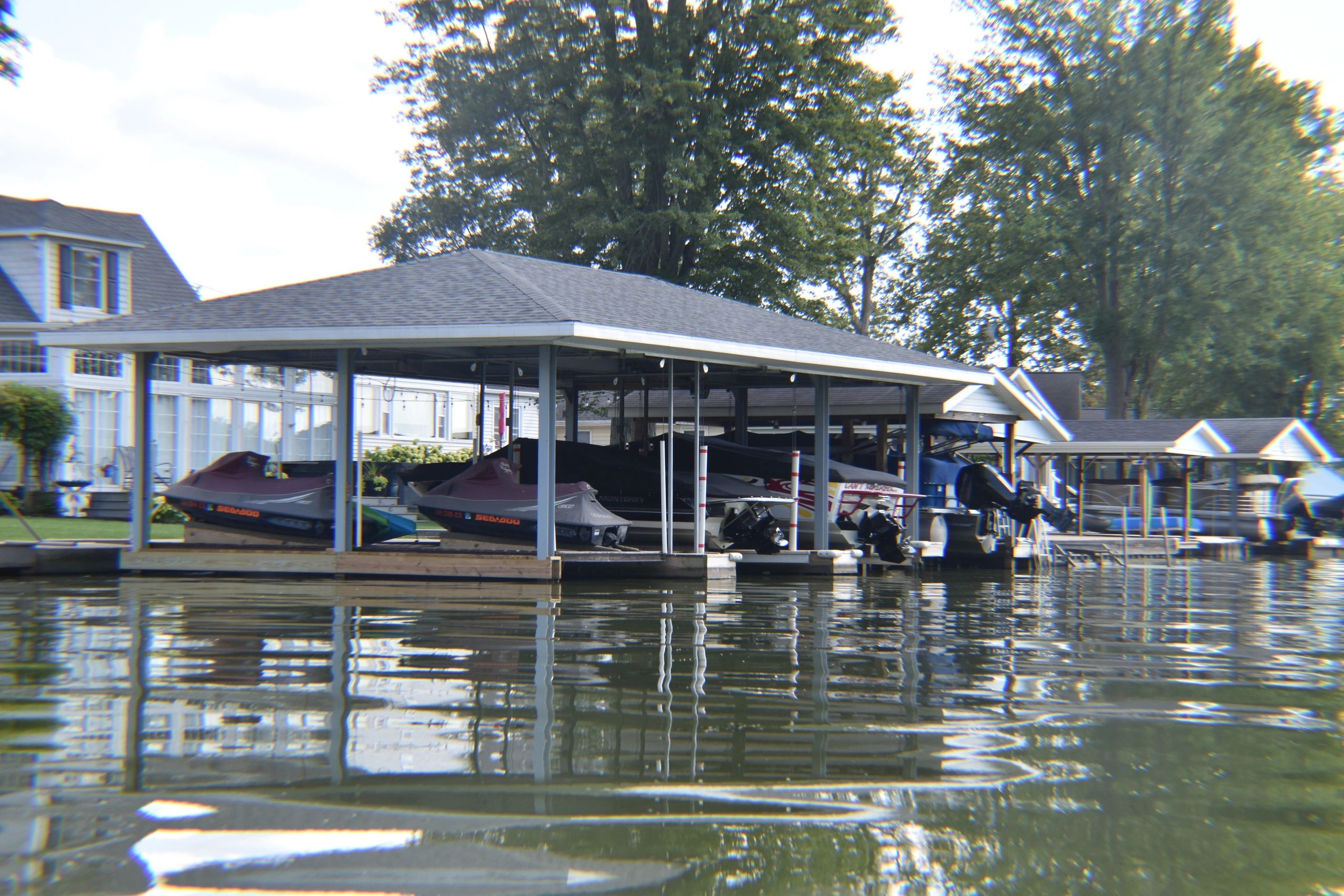 Pontoon and jet skis sitting under shelter as an example of boat docks and seawall repair.