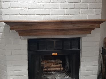 Oak mantel slipped over original brick