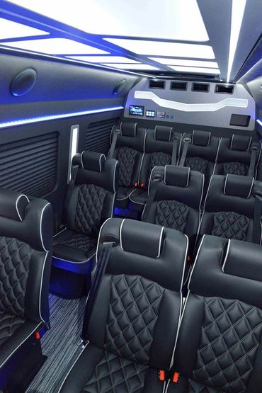 Luxurious black leather seats with blue ambient lighting inside a modern vehicle.