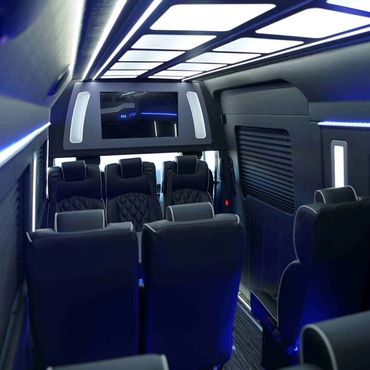 Beautiful black leather seats with ambient blue lighting inside the Mercedes Sprinter Bus.