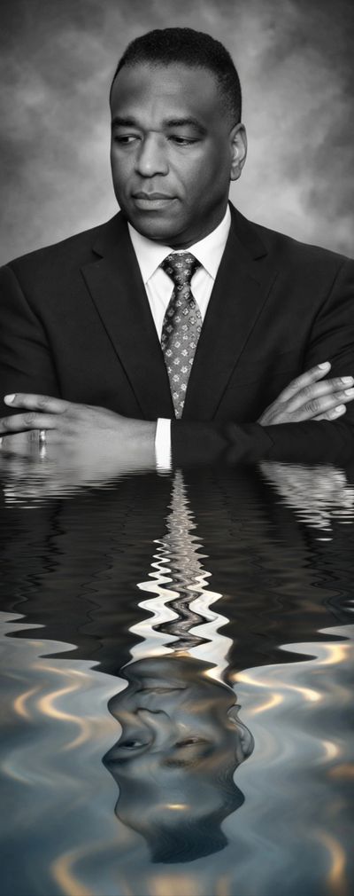 Black and white portrait of a man with a water reflection effect.