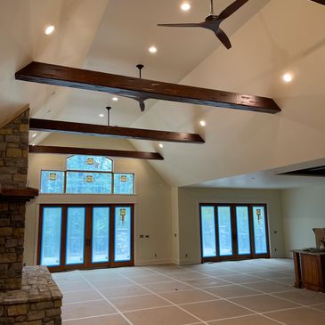 Spacious room with high vaulted ceiling, wooden beams, and large windows with stained glass.