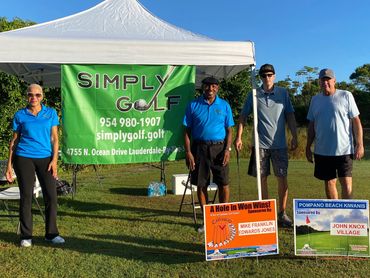 People standing under the simply golf tent