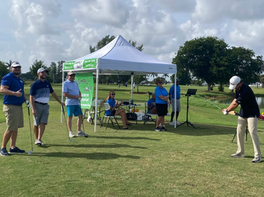 People playing golf beside the tent