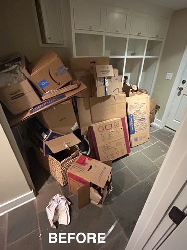 Cluttered entryway filled with stacked cardboard boxes and packing materials.