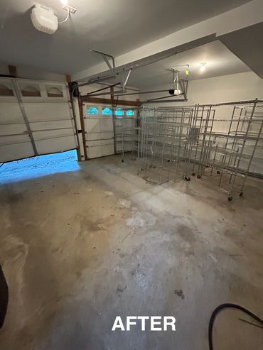 Clean, organized garage with metal shelving units and open garage door.