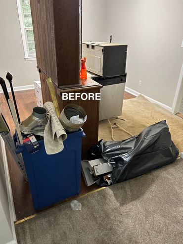 Cluttered room with trash, old appliances, and carpet removal in progress.