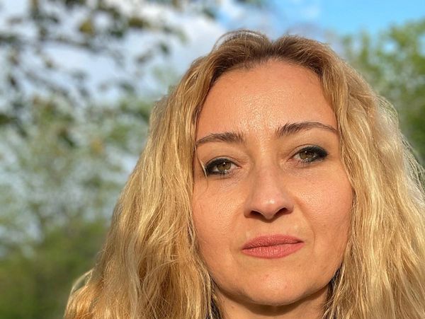 Portrait of a woman with long blonde hair outdoors.
