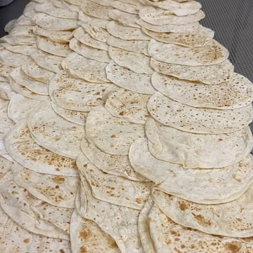 Stacks of flatbreads arranged in rows.