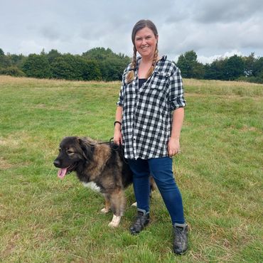 Lu standing with a Caucasian Shepherd on lead