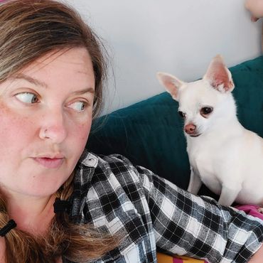 Lu sitting on a sofa with a white Chihuahua