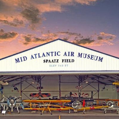 Colorful picture of the Mid-Atlantic Air Museum with a variety of aircrafts inside and out front. 