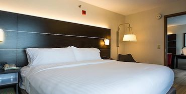 A king sized bed with white bedding in the Holiday Inn Express.