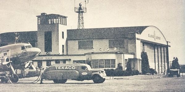 Old picture of RDG airport taken within the 1940's. Picture features a texaco car and plane.
