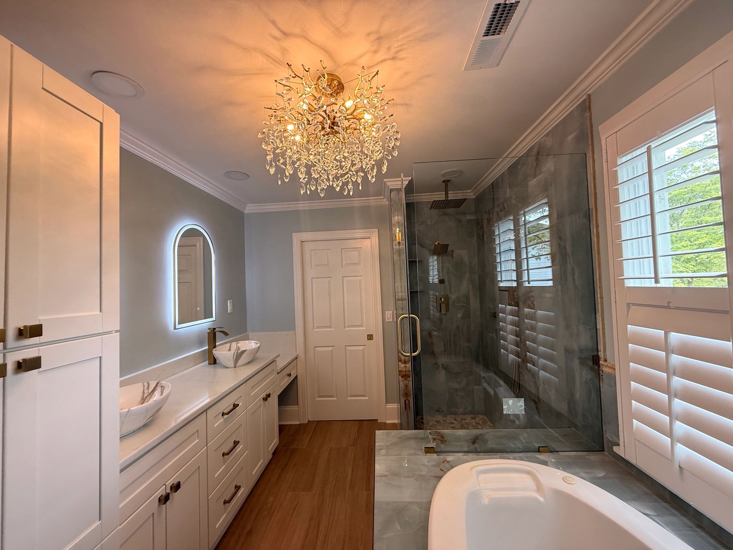 Elegant bathroom with chandelier and modern fixtures.