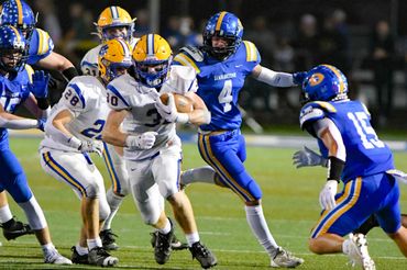 High school football players in action during a night game.