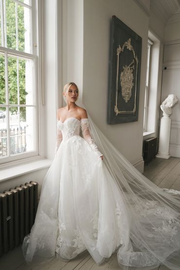 Bride in a vintage wedding gown with lace details, a basque waist, and a sweetheart neckline
