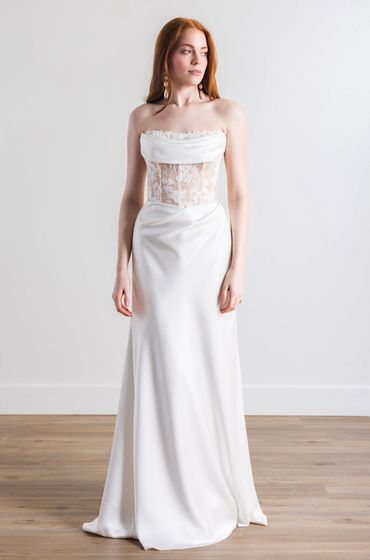A two tone wedding gown with rushing details and a cowl neckline featuring a lace bodice