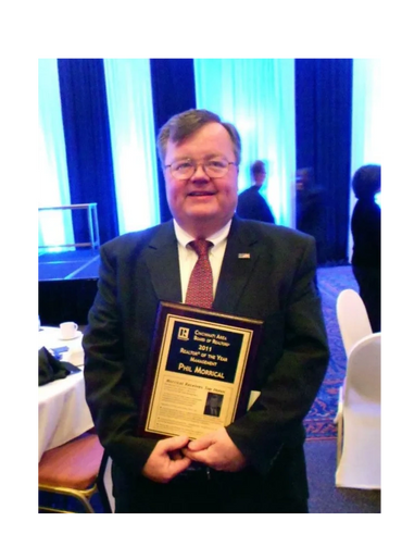 Man in suit holding a 2011 Realtor of the Year award plaque.