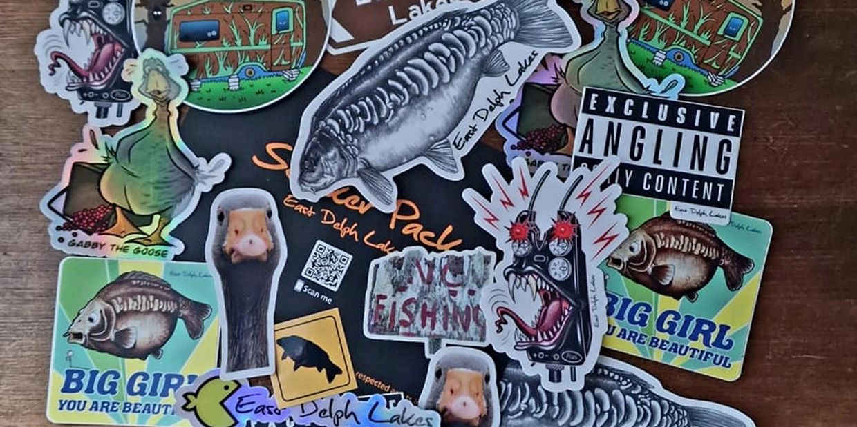Collection of fishing and animal-themed stickers on a wooden surface.
