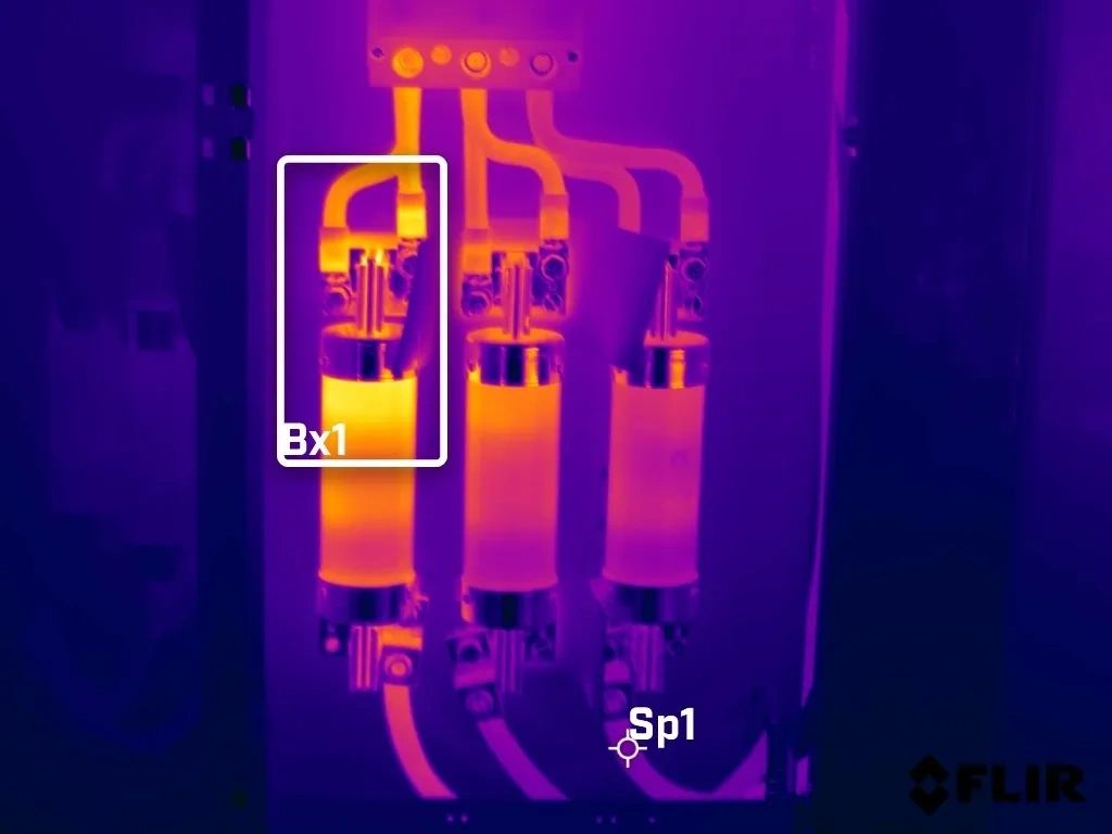 Thermal image of electrical components with heat signatures.
