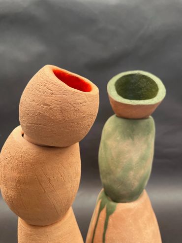 Two stacked, hollow ceramic sculptures with textured surfaces and earthy colors.