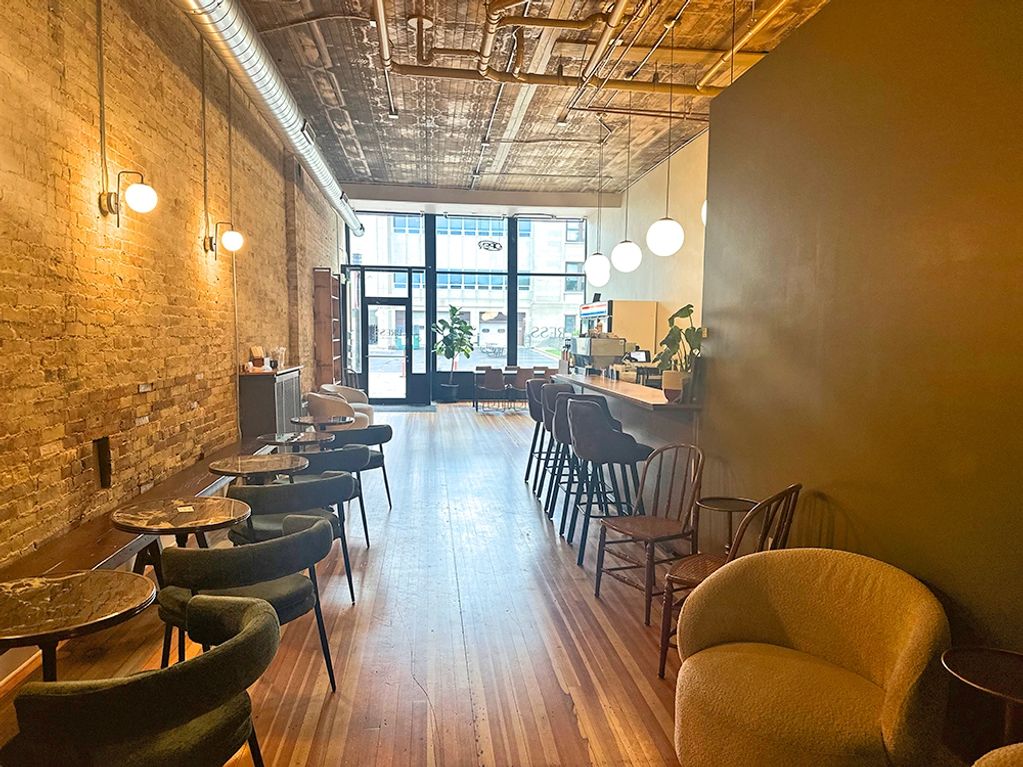 Cozy modern café with wooden floors and warm lighting.