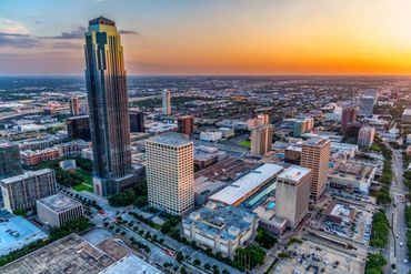 A city skyline at sunset with tall buildings and vibrant sky colors.
