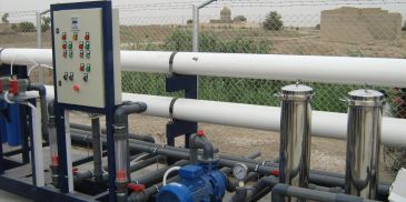 Industrial water filtration system outdoors with control panel.