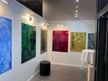 Art gallery corner with vibrant abstract paintings and modern lighting.