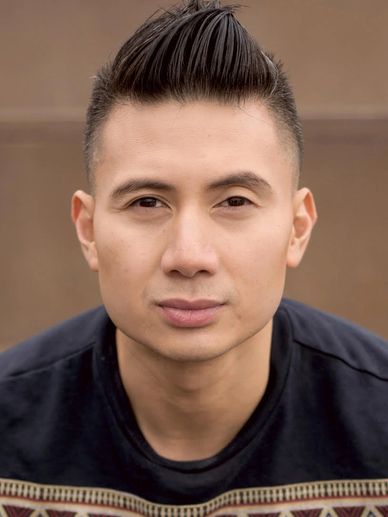 Close-up portrait of a young man with styled hair and a focused expression.