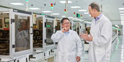 Two engineers discussing in a clean manufacturing facility.