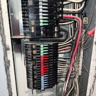 Close-up of an electrical panel with circuit breakers and wiring.