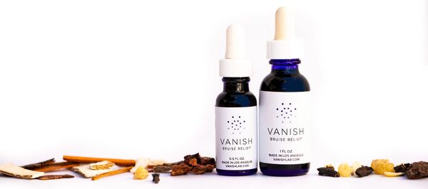 Chinese herbs surrounding bottle of bruise liniment