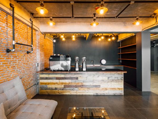 Industrial-style coffee bar with exposed brick and warm lighting.