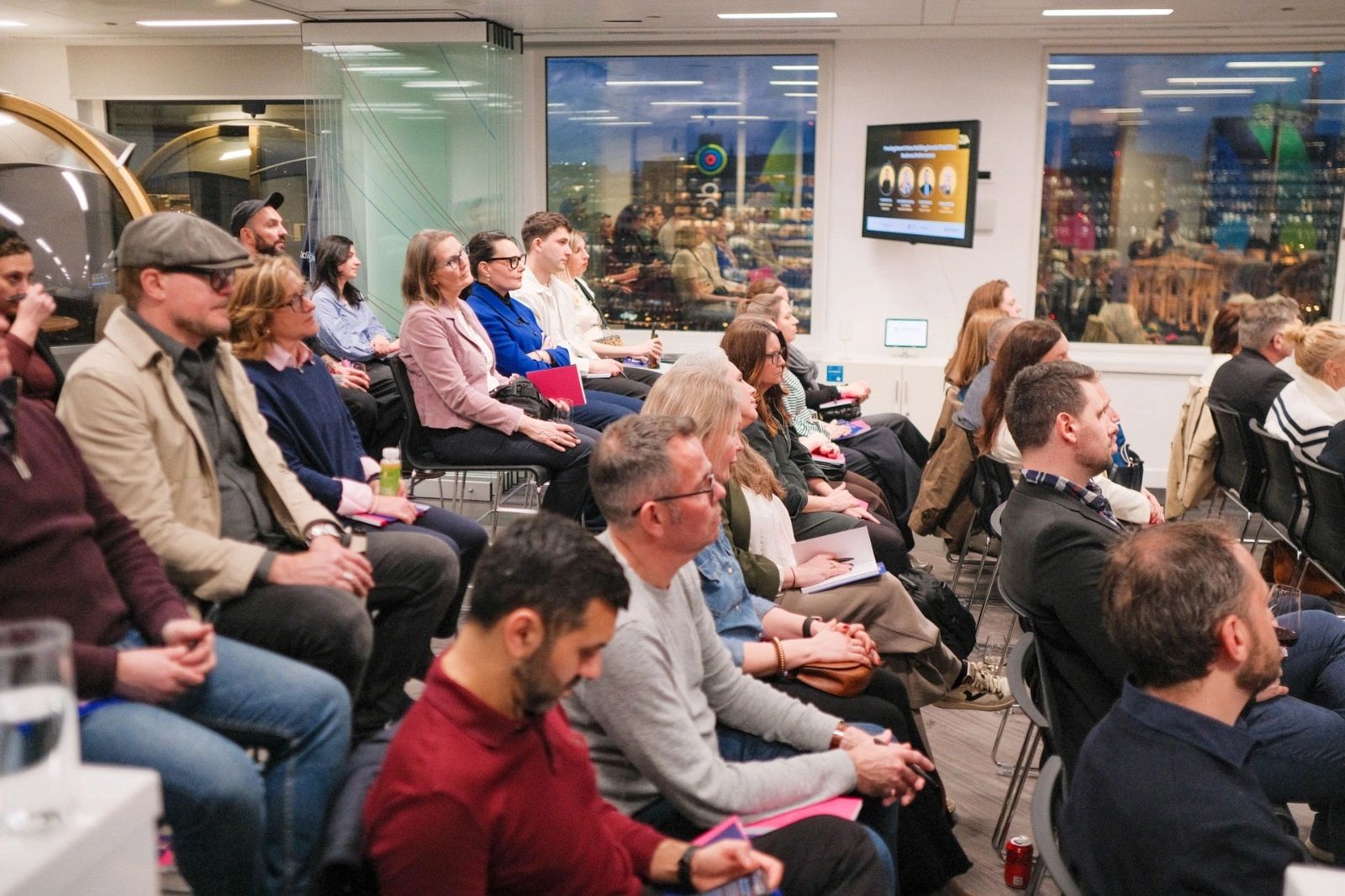 Audience attentively watching a presentation in a modern conference room.